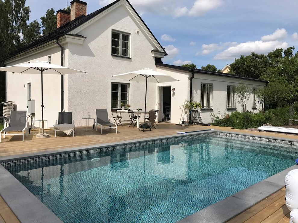 Mid-sized danish backyard rectangular aboveground pool photo in Stockholm with decking