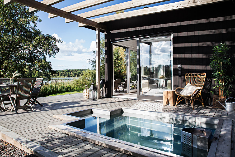 Esempio di una piscina naturale scandinava di medie dimensioni e nel cortile laterale con pedane
