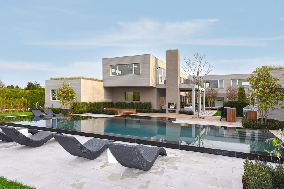Idee per un'ampia piscina a sfioro infinito contemporanea rettangolare dietro casa con una vasca idromassaggio
