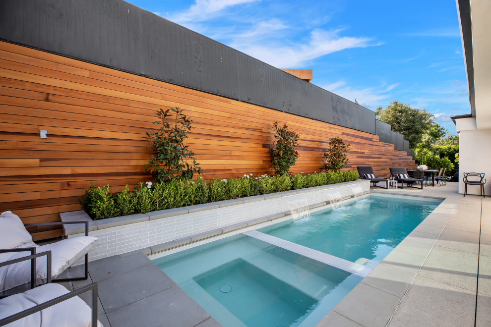 This is an example of a contemporary rectangular swimming pool in Los Angeles with a water feature.
