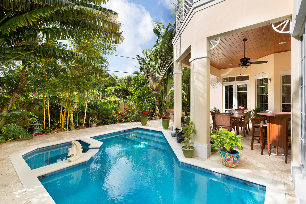 Foto di una piscina naturale tropicale personalizzata dietro casa e di medie dimensioni con una vasca idromassaggio e pavimentazioni in cemento