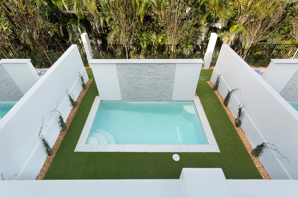 На фото: естественный, прямоугольный бассейн среднего размера на заднем дворе в современном стиле с покрытием из декоративного бетона с
