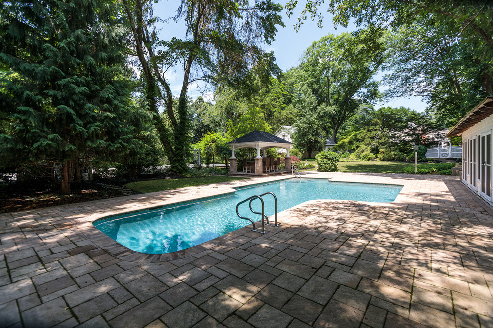 Idee per una grande piscina classica personalizzata dietro casa con una dépendance a bordo piscina e pavimentazioni in pietra naturale