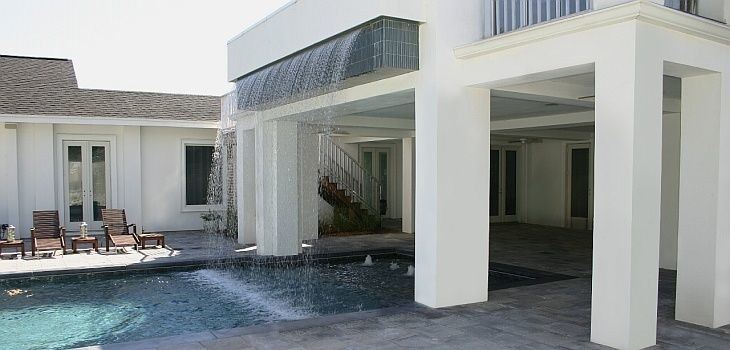 Foto de piscina con fuente grande rectangular en patio trasero con adoquines de ladrillo