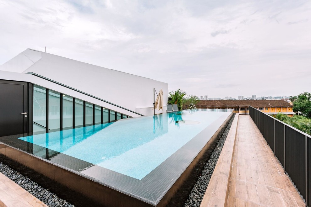 Idee per una piscina a sfioro infinito minimal rettangolare sul tetto con piastrelle