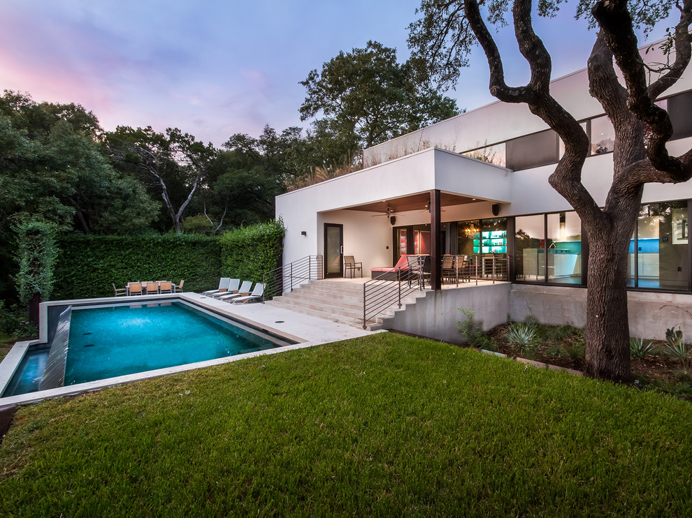Стильный дизайн: прямоугольный бассейн-инфинити на заднем дворе в современном стиле - последний тренд