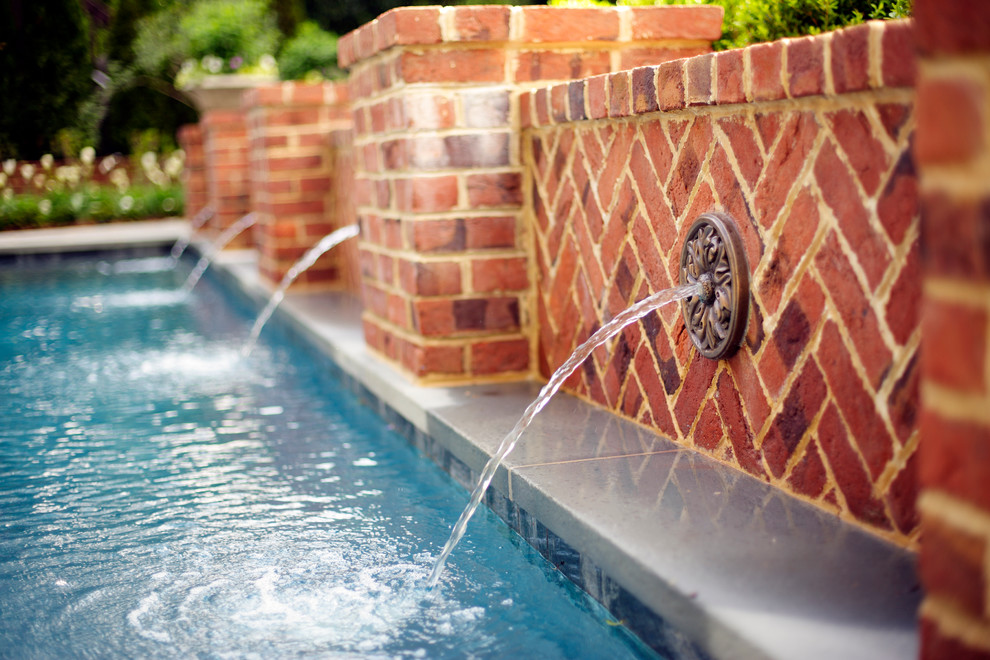 Modelo de piscina con fuente natural clásica rectangular en patio trasero con adoquines de piedra natural