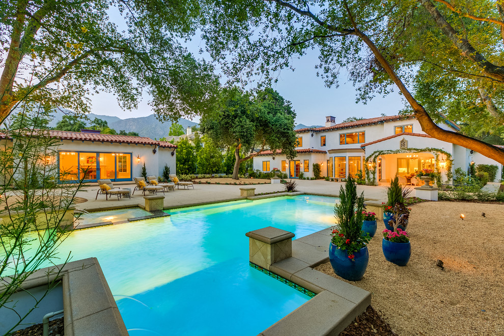 Imagen de casa de la piscina y piscina alargada mediterránea grande rectangular en patio trasero con losas de hormigón