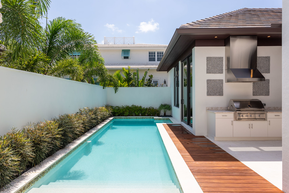 Inspiration pour une piscine design rectangle avec une cour et une terrasse en bois.