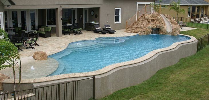 Foto de piscina con tobogán elevada marinera grande a medida en patio trasero con suelo de baldosas