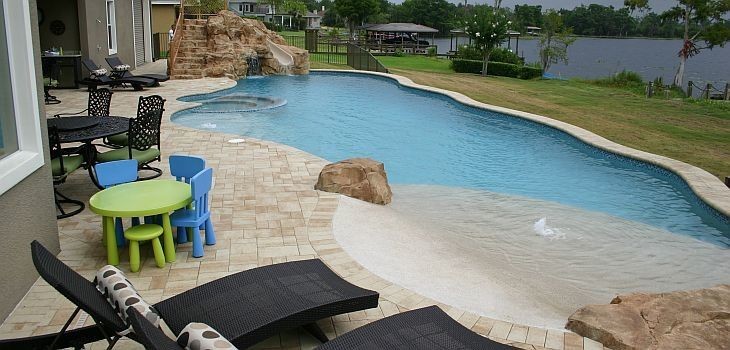Idee per una grande piscina fuori terra costiera personalizzata dietro casa con un acquascivolo e piastrelle