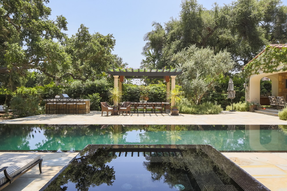Idee per una grande piscina a sfioro infinito mediterranea rettangolare dietro casa con una dépendance a bordo piscina e pavimentazioni in pietra naturale