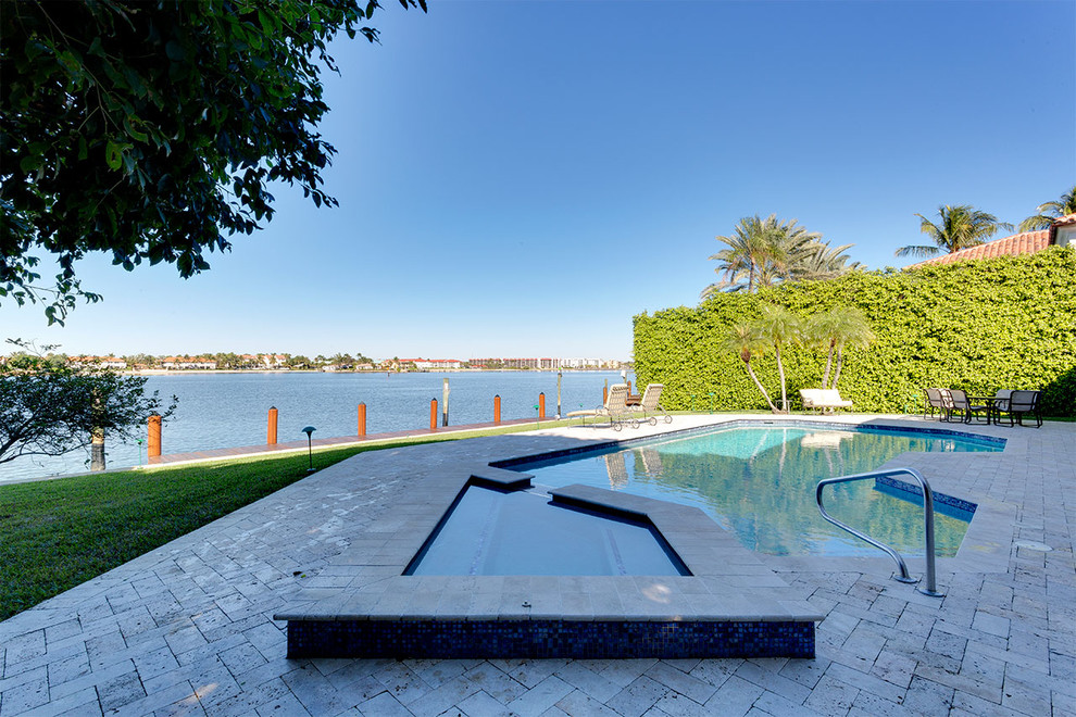 Стильный дизайн: естественный бассейн среднего размера, произвольной формы на заднем дворе в средиземноморском стиле с джакузи и мощением клинкерной брусчаткой - последний тренд