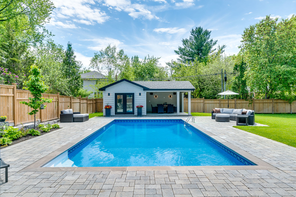 Diseño de casa de la piscina y piscina alargada clásica renovada grande rectangular en patio trasero con adoquines de piedra natural