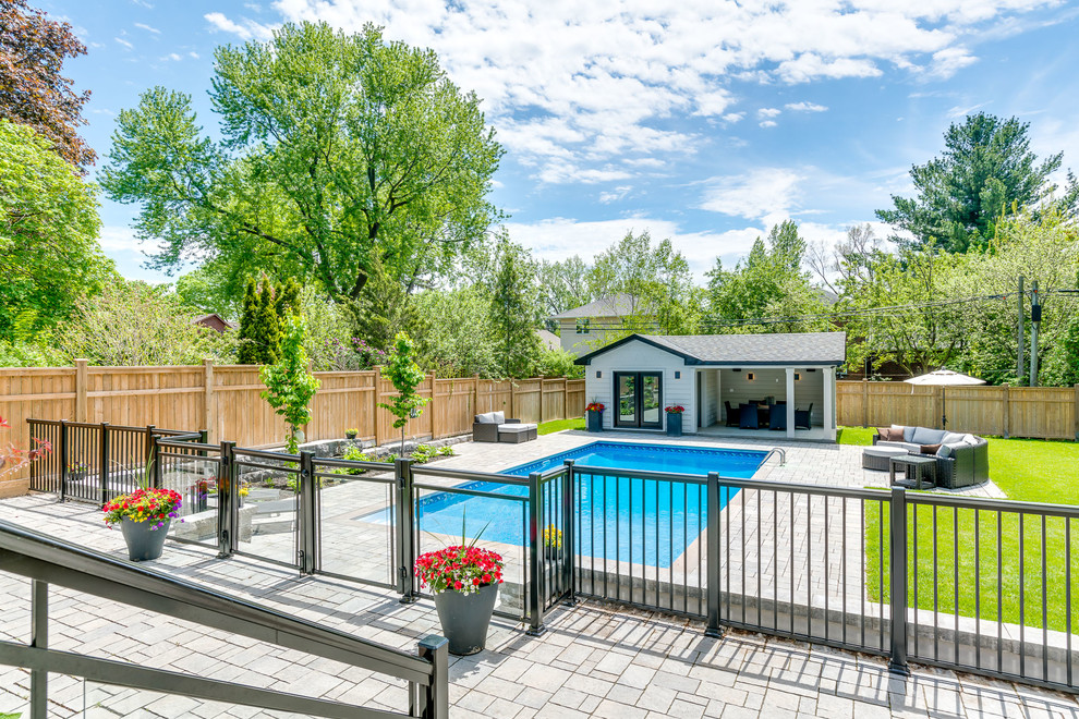 Imagen de casa de la piscina y piscina alargada clásica renovada grande rectangular en patio trasero con adoquines de piedra natural
