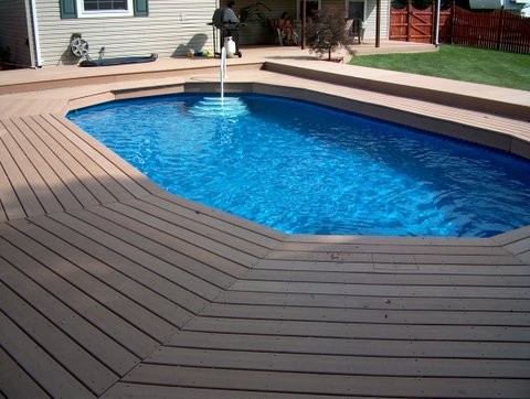 Cette photo montre un couloir de nage arrière chic de taille moyenne et sur mesure avec une terrasse en bois.