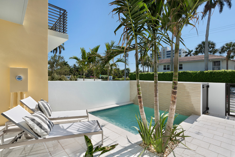 Small contemporary rectangular swimming pool in Miami with concrete paving.