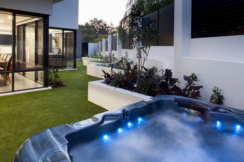 Aménagement d'une petite piscine hors-sol et arrière moderne rectangle avec un bain bouillonnant.