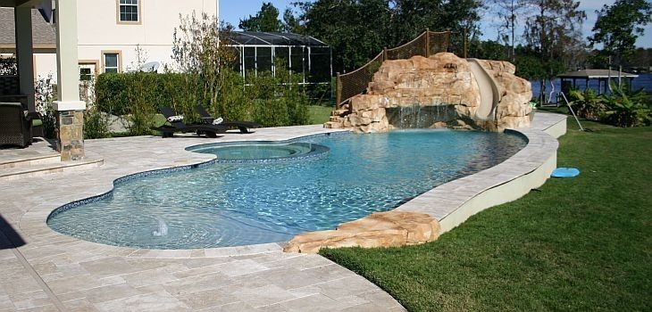 Foto de piscina con tobogán marinera de tamaño medio redondeada en patio trasero con adoquines de ladrillo