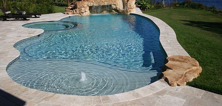 Diseño de piscina con tobogán marinera de tamaño medio redondeada en patio trasero con adoquines de ladrillo