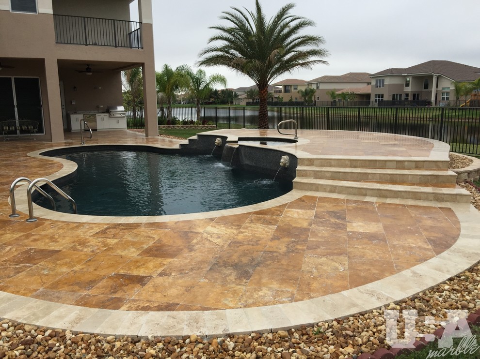Foto de piscina elevada grande tipo riñón en patio trasero con adoquines de piedra natural