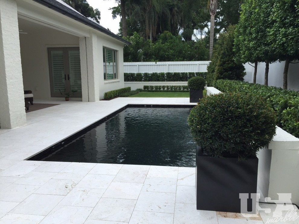 Foto de piscina elevada moderna de tamaño medio con adoquines de piedra natural