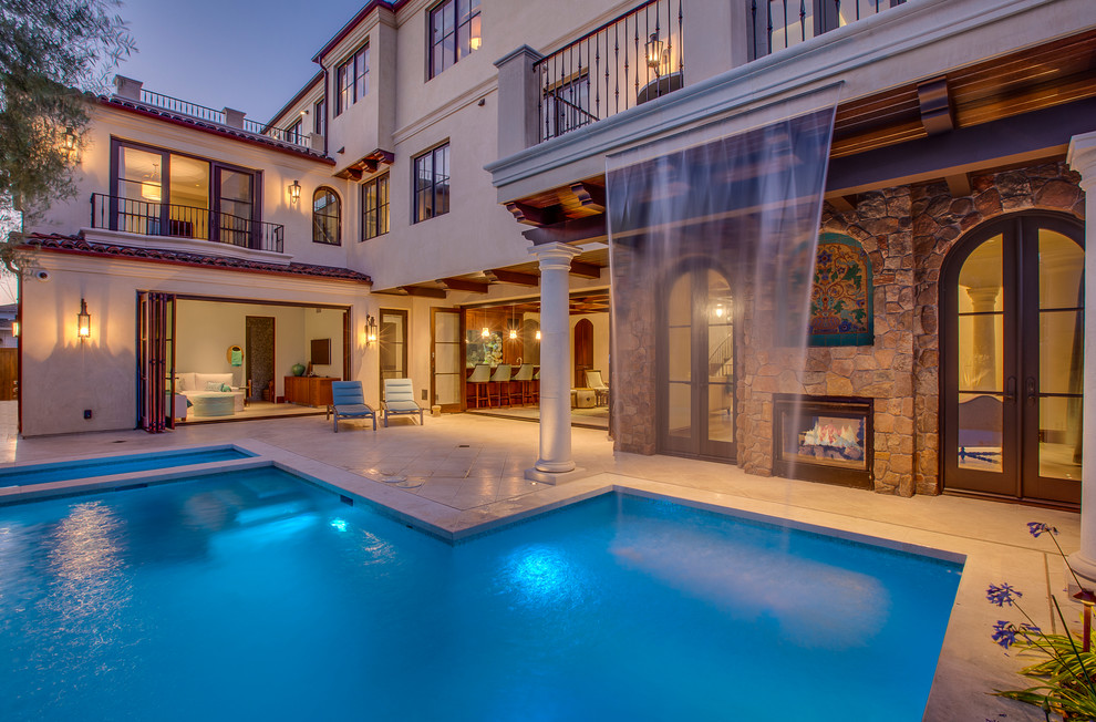 Example of a large tuscan backyard tile and rectangular pool fountain design in Los Angeles