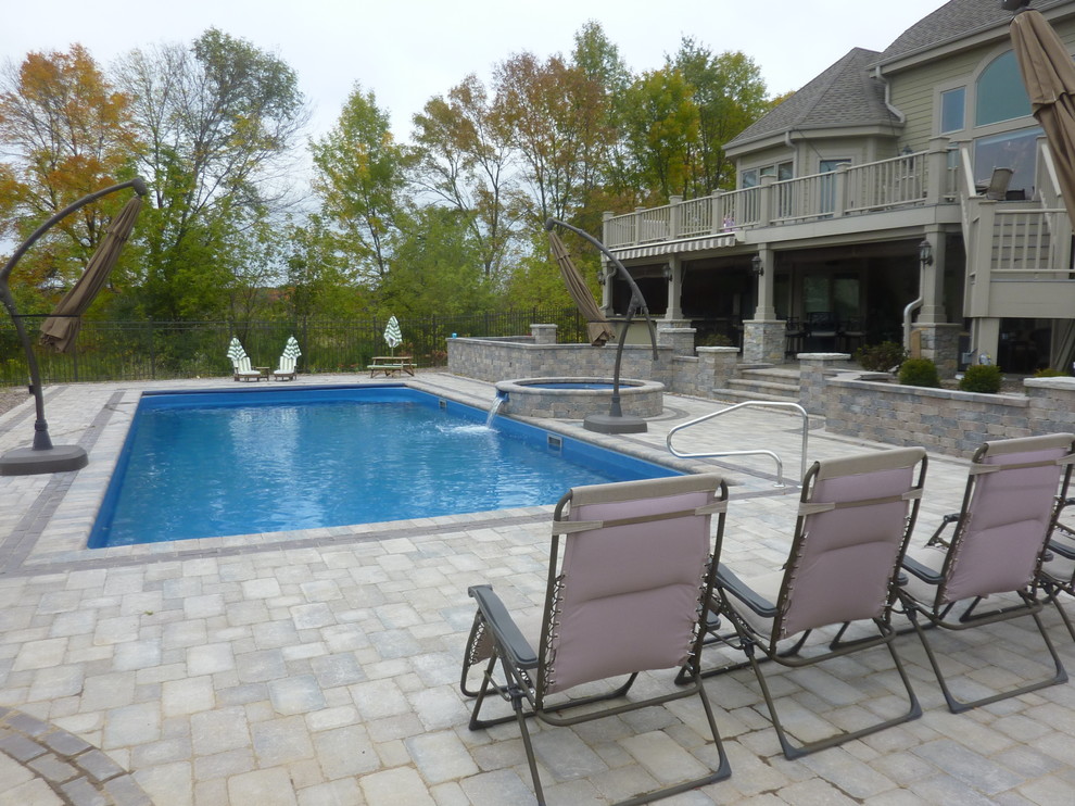 Mid-sized backyard concrete paver and rectangular hot tub photo in Milwaukee