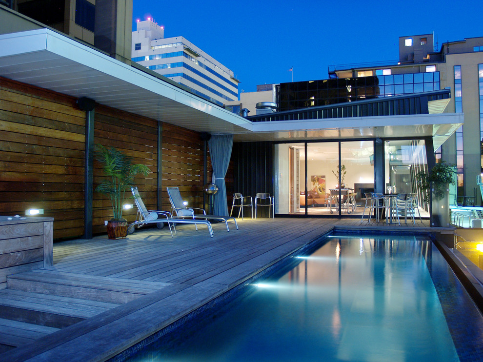 Exemple d'une piscine naturelle tendance rectangle avec une terrasse en bois.