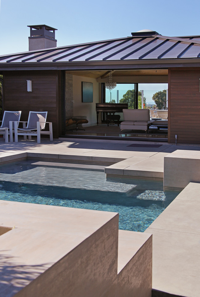 Diseño de piscina moderna de tamaño medio a medida en patio con losas de hormigón