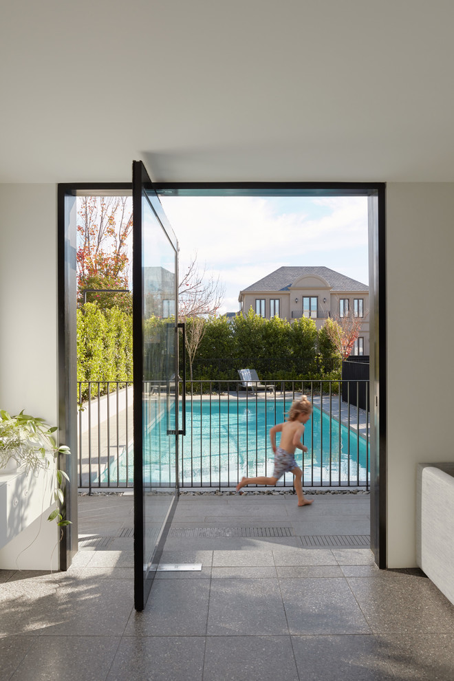 Foto de piscina moderna de tamaño medio rectangular con adoquines de hormigón