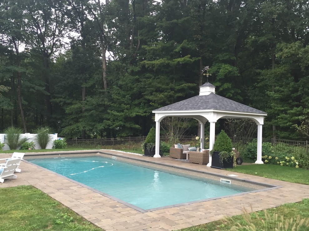 Diseño de piscina clásica grande rectangular en patio trasero