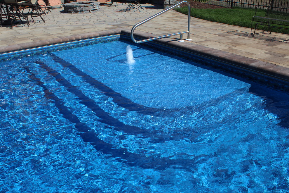 Пример оригинального дизайна: огромный прямоугольный бассейн на заднем дворе в классическом стиле с фонтаном и мощением клинкерной брусчаткой