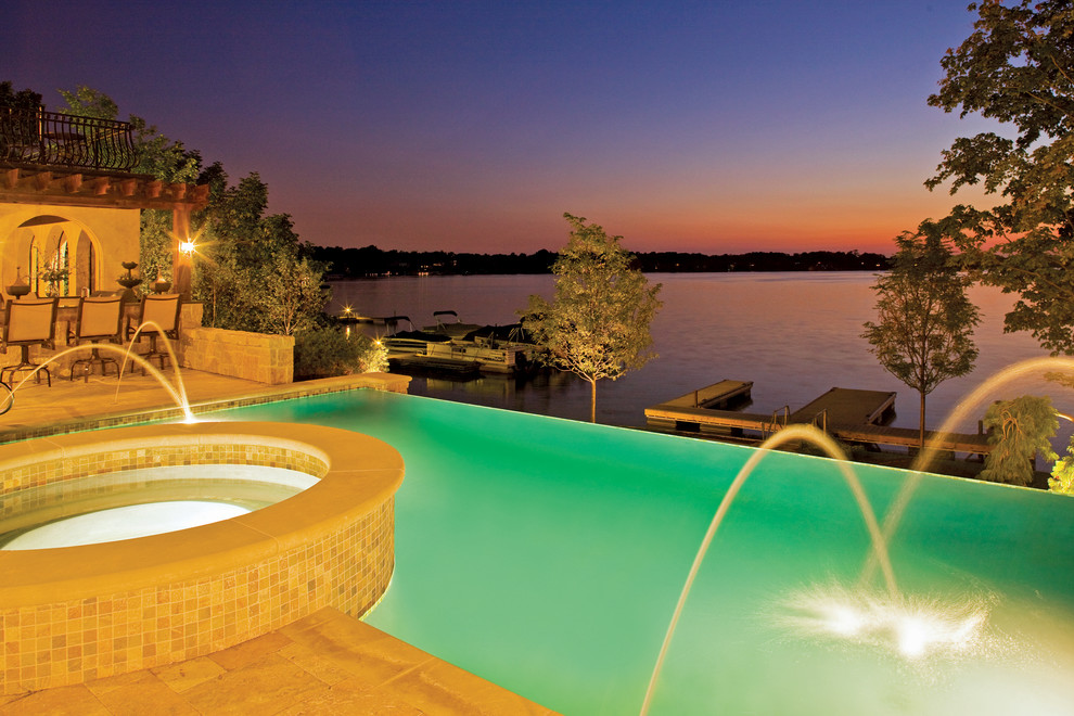 Esempio di una piscina a sfioro infinito mediterranea rettangolare di medie dimensioni e dietro casa con fontane