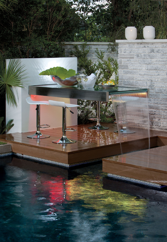 Inspiration pour une piscine design avec une terrasse en bois.
