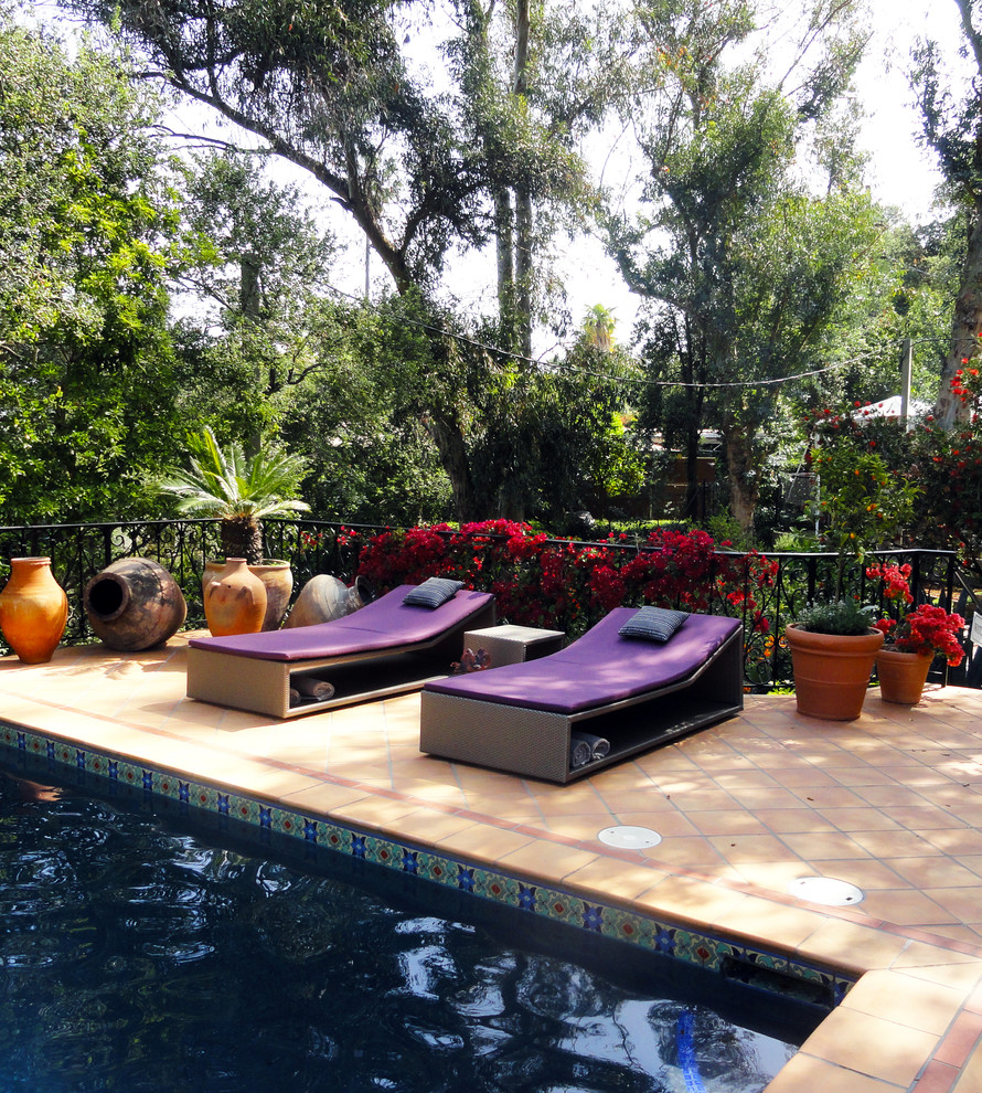 Ejemplo de piscinas y jacuzzis alargados mediterráneos grandes rectangulares en patio trasero con suelo de baldosas