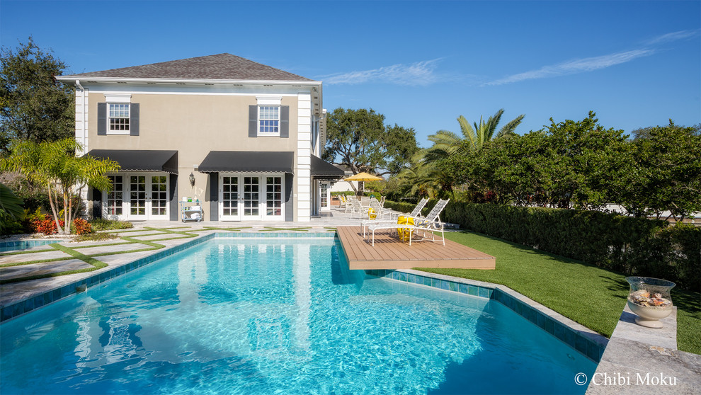 Esempio di una grande piscina minimalista rettangolare dietro casa con pavimentazioni in pietra naturale