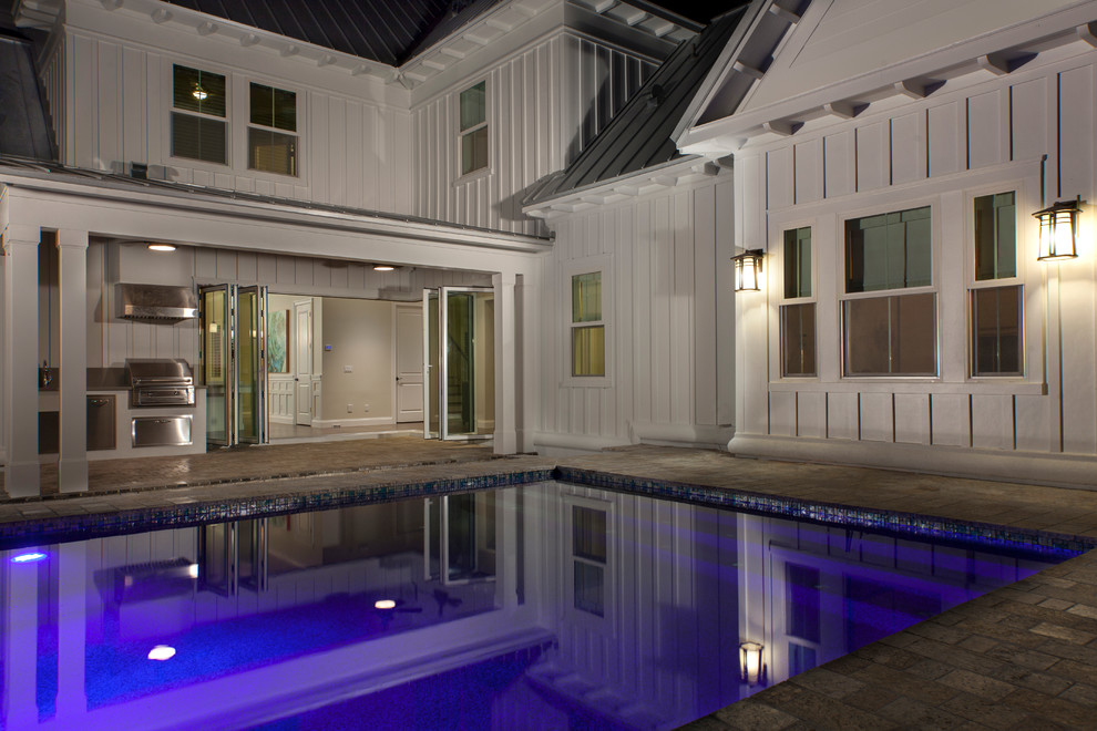 Ejemplo de piscina de estilo de casa de campo grande rectangular en patio trasero