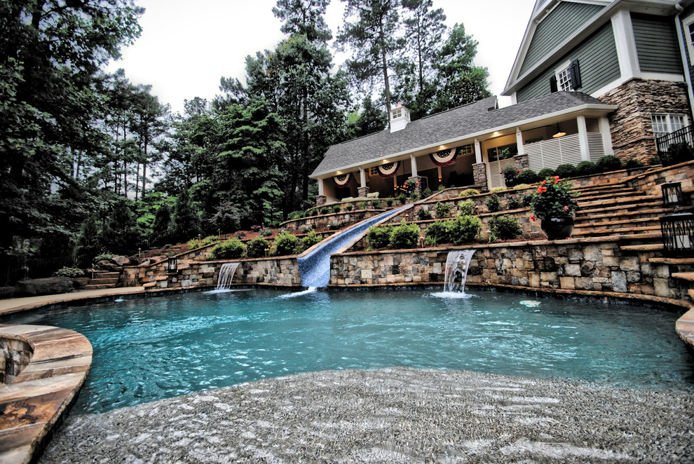 Bild på en stor vintage anpassad pool på baksidan av huset, med vattenrutschkana och naturstensplattor