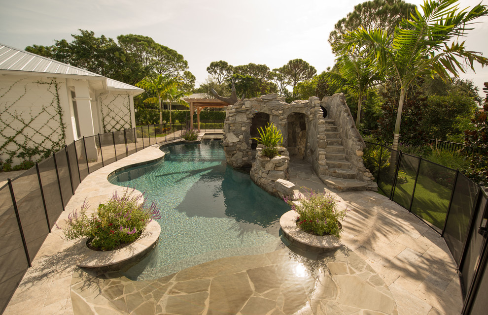 Ispirazione per una piscina stile americano personalizzata di medie dimensioni e dietro casa con un acquascivolo e pavimentazioni in pietra naturale