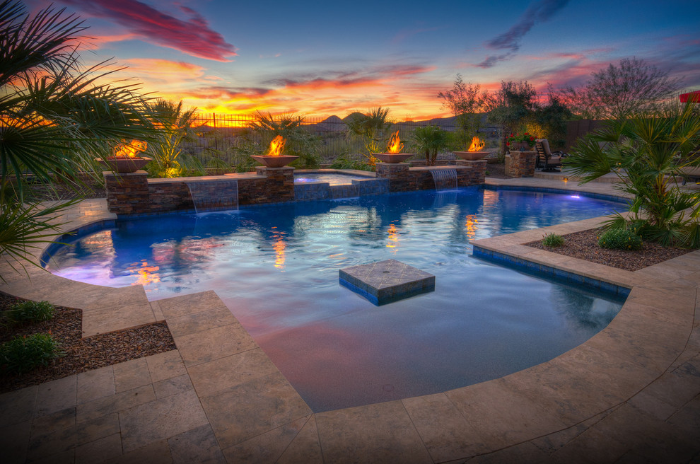 Diseño de piscina con fuente actual grande a medida en patio trasero con adoquines de piedra natural