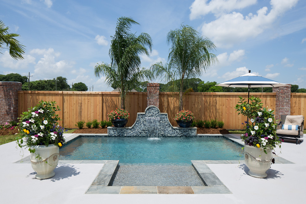 Inspiration for a small tropical backyard concrete and rectangular pool fountain remodel in New Orleans