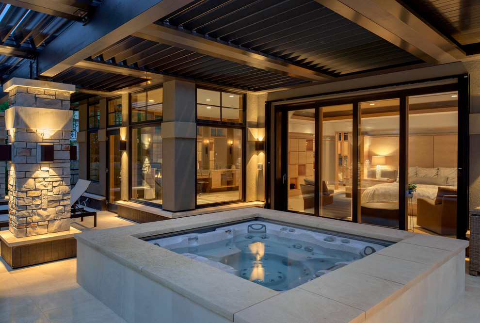 Esempio di un'ampia piscina design dietro casa con fontane e piastrelle
