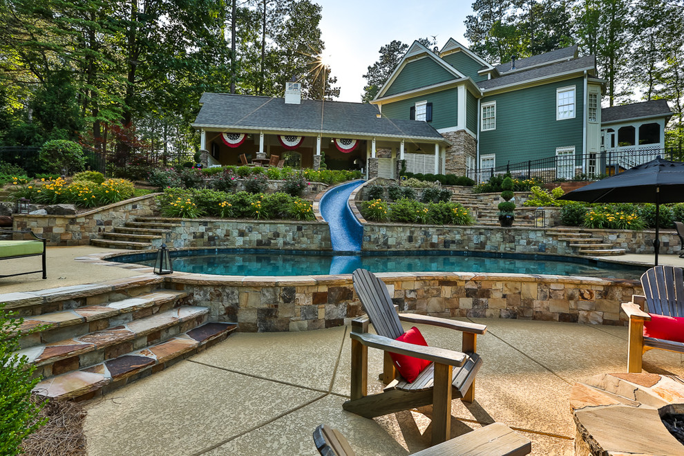Inspiration för en mellanstor amerikansk anpassad pool på baksidan av huset, med vattenrutschkana och trädäck