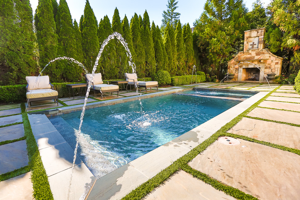 Imagen de piscina con fuente minimalista pequeña rectangular en patio trasero con adoquines de piedra natural