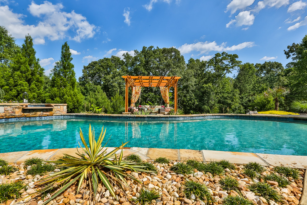 Inspiration for a large world-inspired back custom shaped natural swimming pool in Atlanta with a water feature and decking.