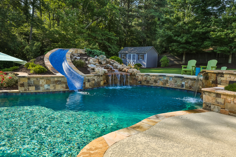 Großer Schwimmteich hinter dem Haus in individueller Form mit Wasserrutsche und Stempelbeton in Atlanta