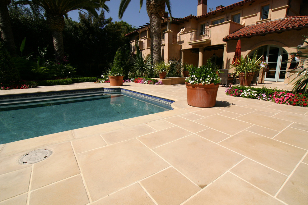 Idée de décoration pour une grande piscine arrière méditerranéenne rectangle avec des pavés en pierre naturelle.
