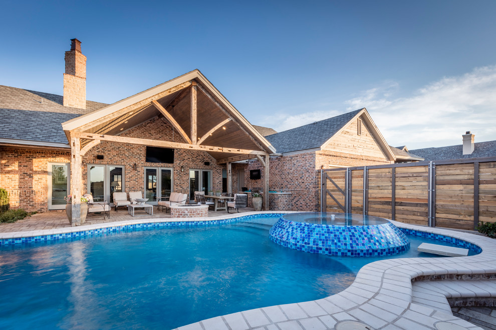 Ispirazione per una grande piscina stile rurale personalizzata dietro casa con una vasca idromassaggio e pavimentazioni in mattoni