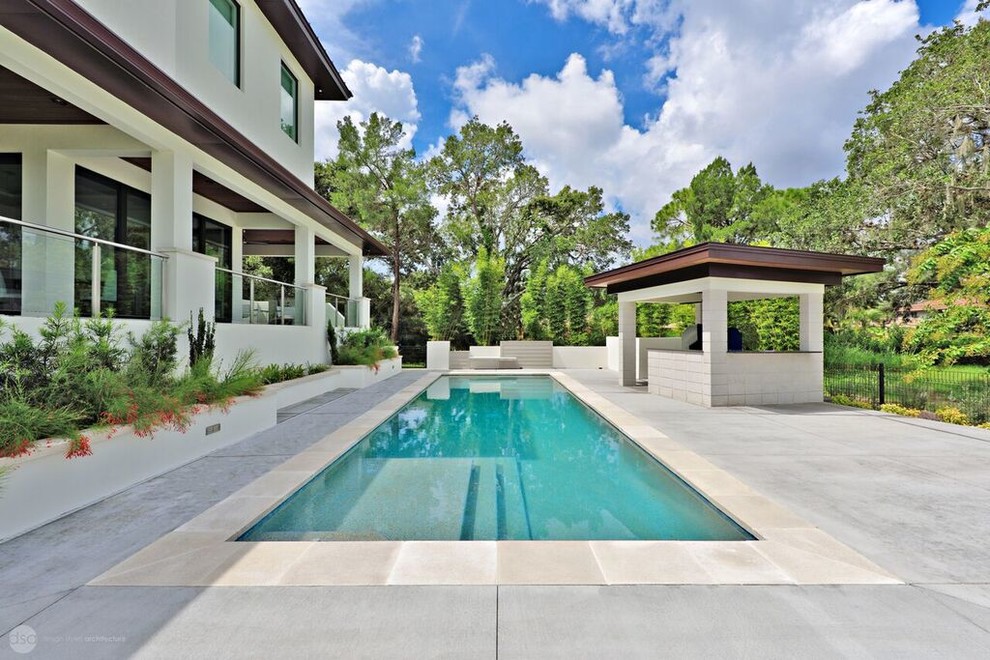 Großer Moderner Pool hinter dem Haus in rechteckiger Form mit Betonplatten in Tampa